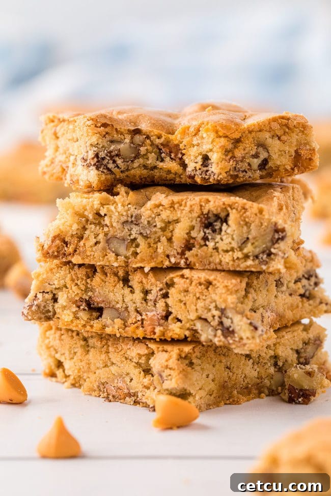 A perfectly stacked pile of four golden-brown butterscotch blondies, showcasing their rich color and chewy texture, ready to be enjoyed.