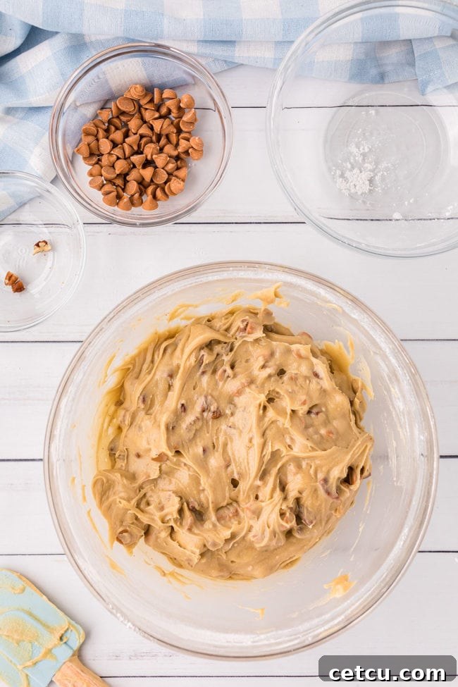 Smooth, golden butterscotch blondie batter in a clear glass bowl, ready for the next step of baking.