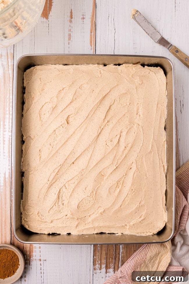 frosting spread on top of an apple cake
