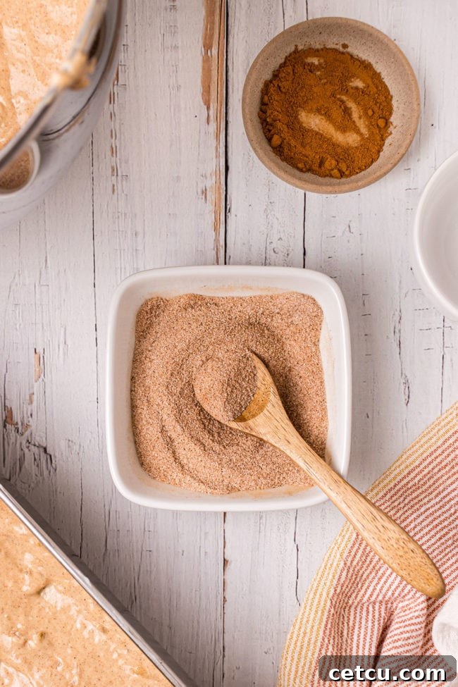 cinnamon and sugar in a square bowl with a small wooden spoon