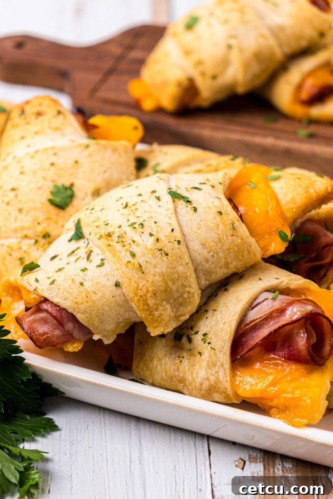 Crescent Roll Sandwiches with ham and cheese arranged neatly on a white tray.