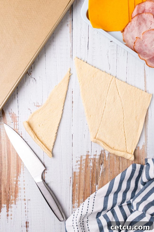 Step 1: Unrolling crescent dough triangles on a baking sheet.