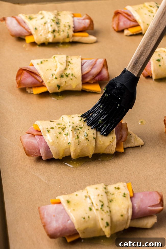 Step 6: Brushing the seasoned melted butter over the tops of the crescent roll-ups.