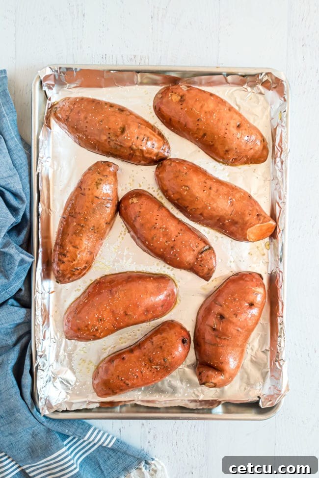 halved sweet potatoes on a baking sheet flesh side down