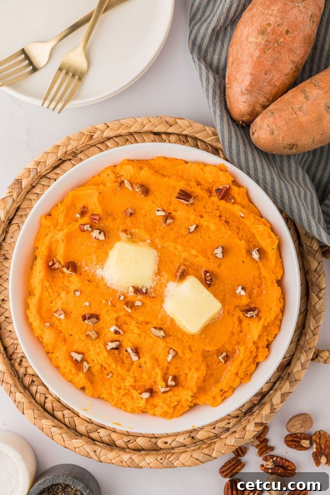 a bowl of mashed sweet potatoes topped with chopped pecans and butter