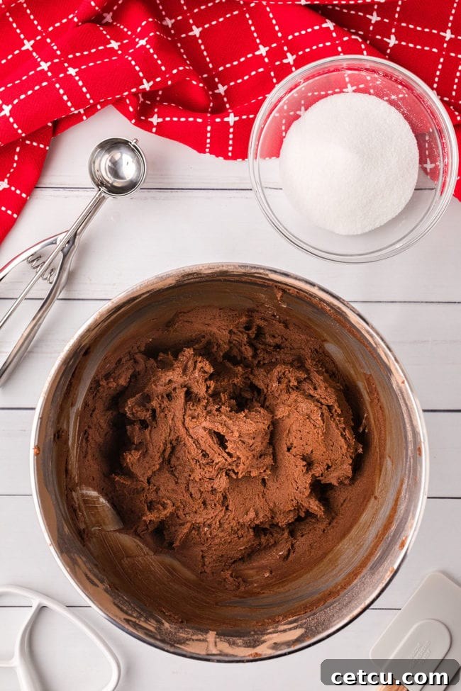 Chocolate kiss cookie dough in a metal mixing bowl, ready for shaping and baking.