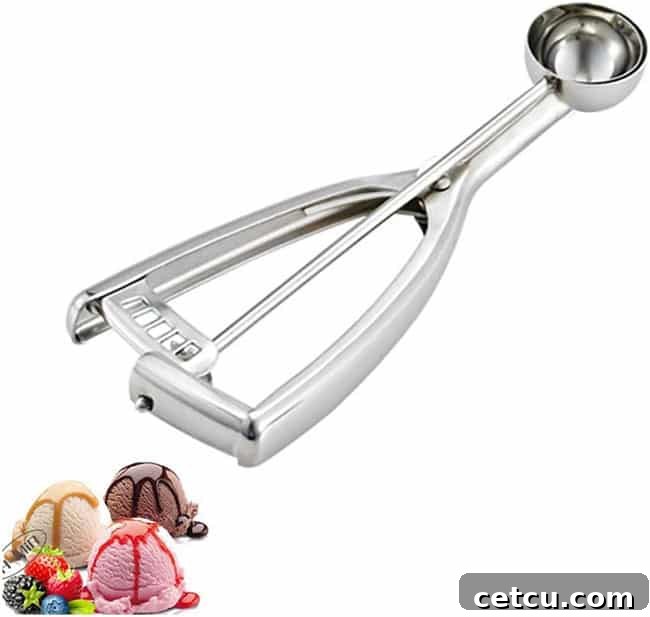 A high-quality, stainless steel cookie scoop resting on a wooden surface, highlighting its utility in baking.
