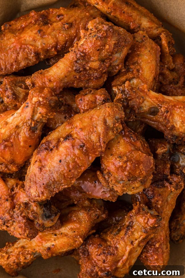 Perfectly crispy baked chicken wings coated in a rich buffalo sauce, presented in a bowl and ready to be enjoyed.