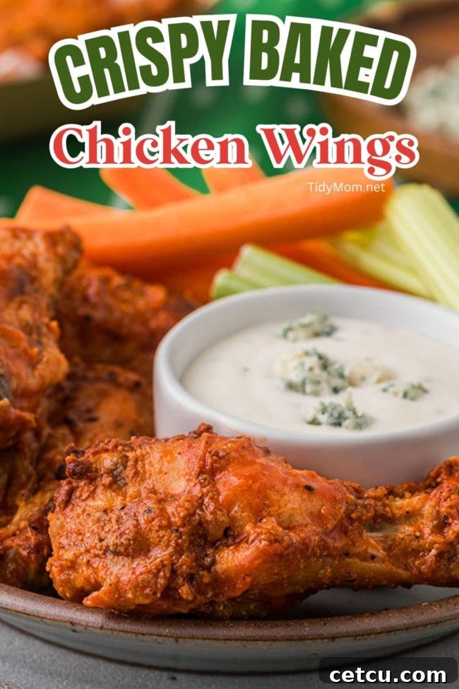 A plate of crispy chicken wings served with carrot and celery sticks and a side of blue cheese dressing.