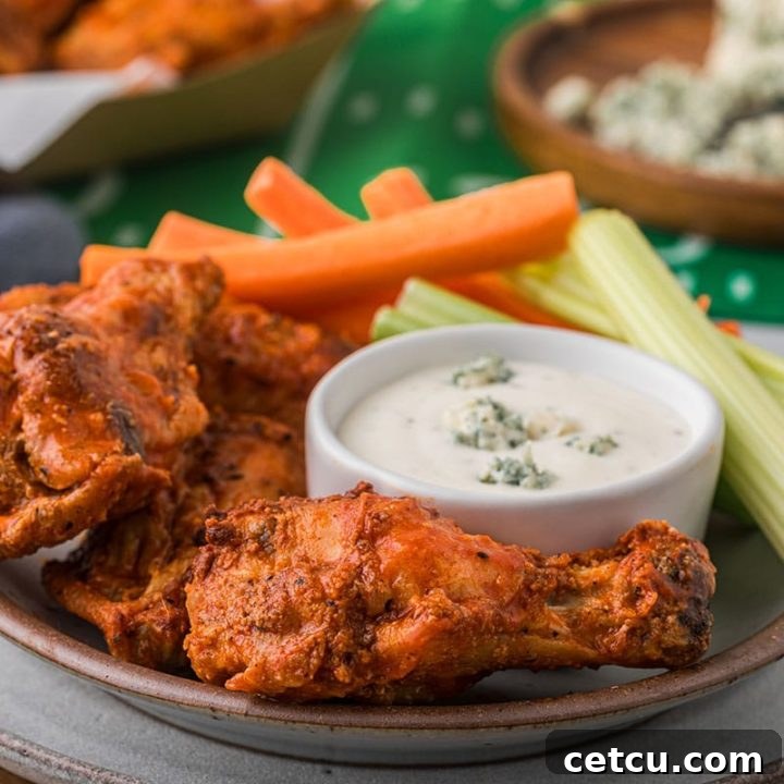 Delicious crispy oven baked chicken wings, perfectly golden with a side of blue cheese dressing for dipping.