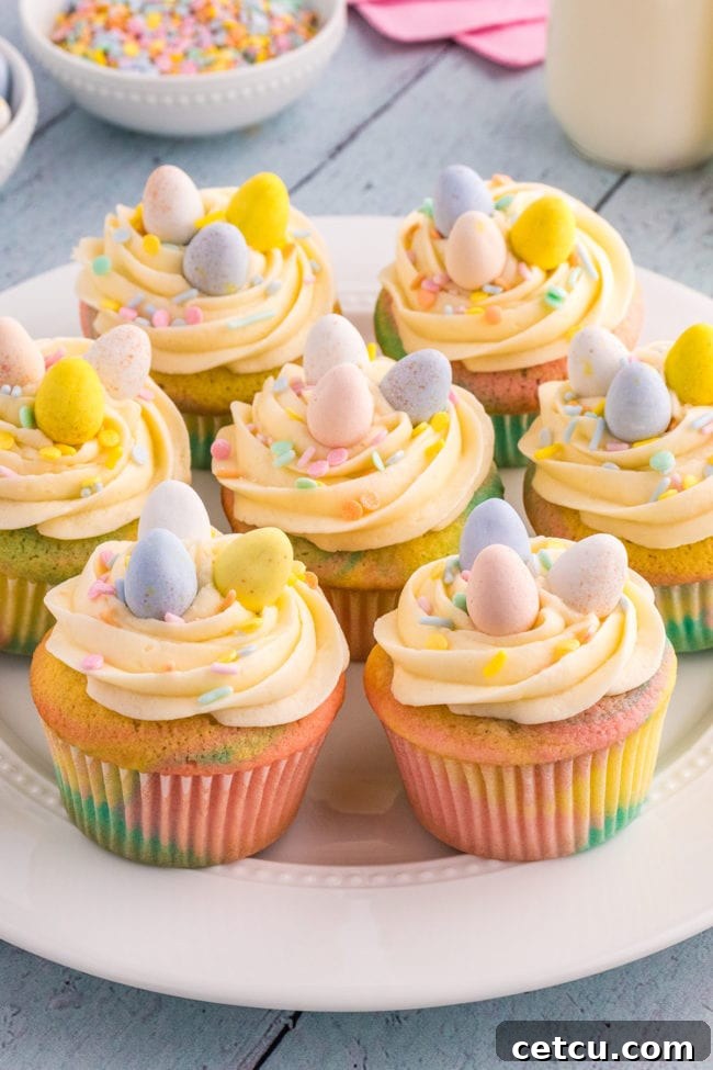 A delightful plate of various Easter cupcakes, each beautifully decorated with buttercream, sprinkles, and mini chocolate eggs, ready to be enjoyed.