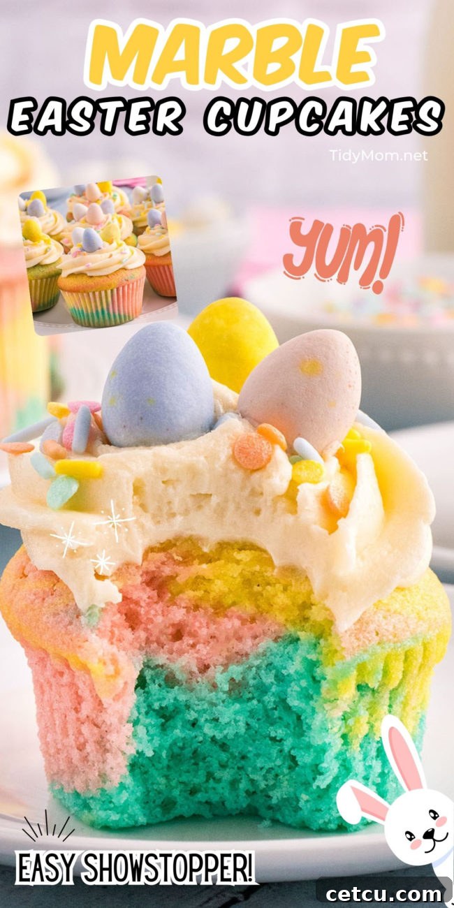 A colorful marble cupcake with a bite taken out, revealing its pastel-swirled interior, topped with white buttercream, sprinkles, and a mini chocolate egg.