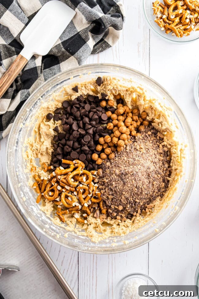 Glass mixing bowl filled with rich cookie dough, ready for the vibrant addition of all the diverse mix-ins.