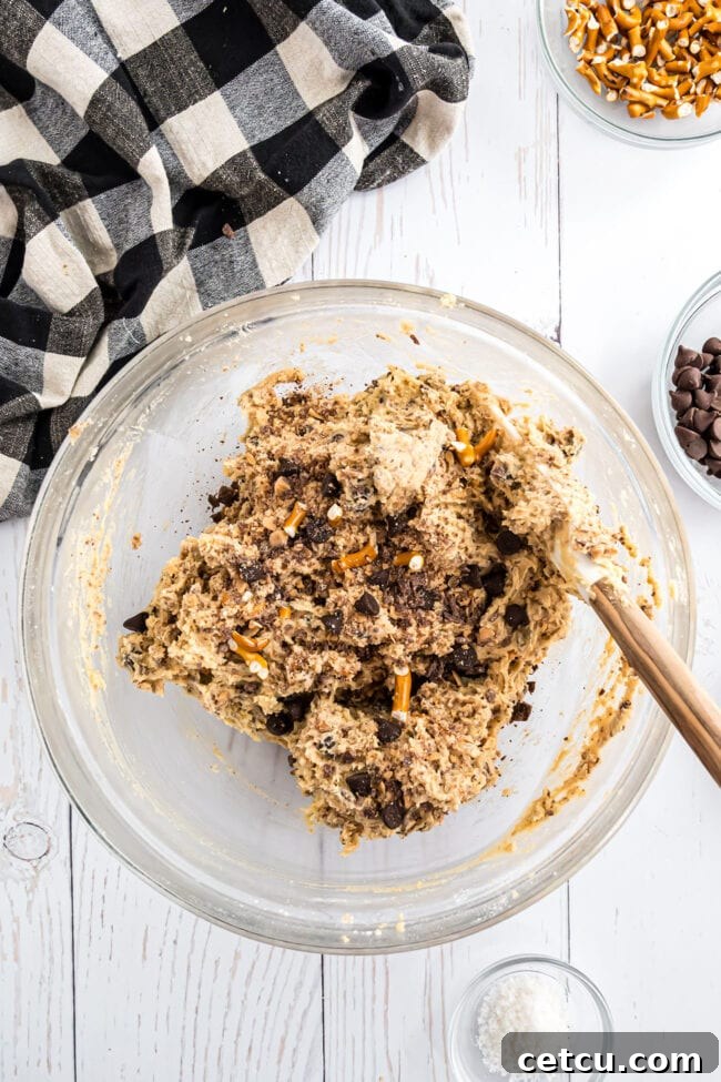 A pristine glass bowl showcasing perfectly combined Kitchen Sink Cookie dough, a smooth canvas awaiting the final touches.