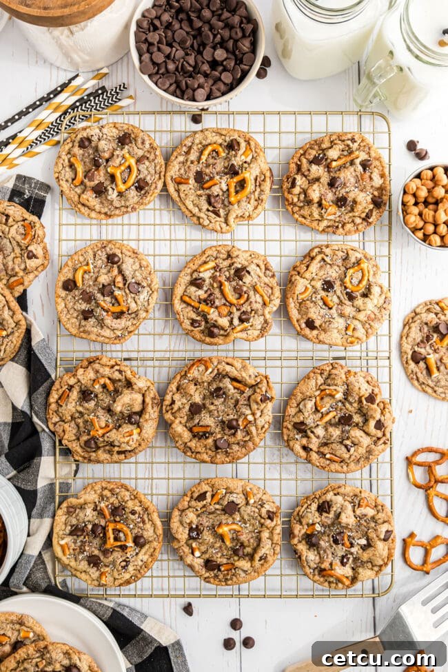 Freshly baked Kitchen Sink Cookies cooling on a wire rack, allowing air circulation for a perfectly crisp exterior and soft interior.