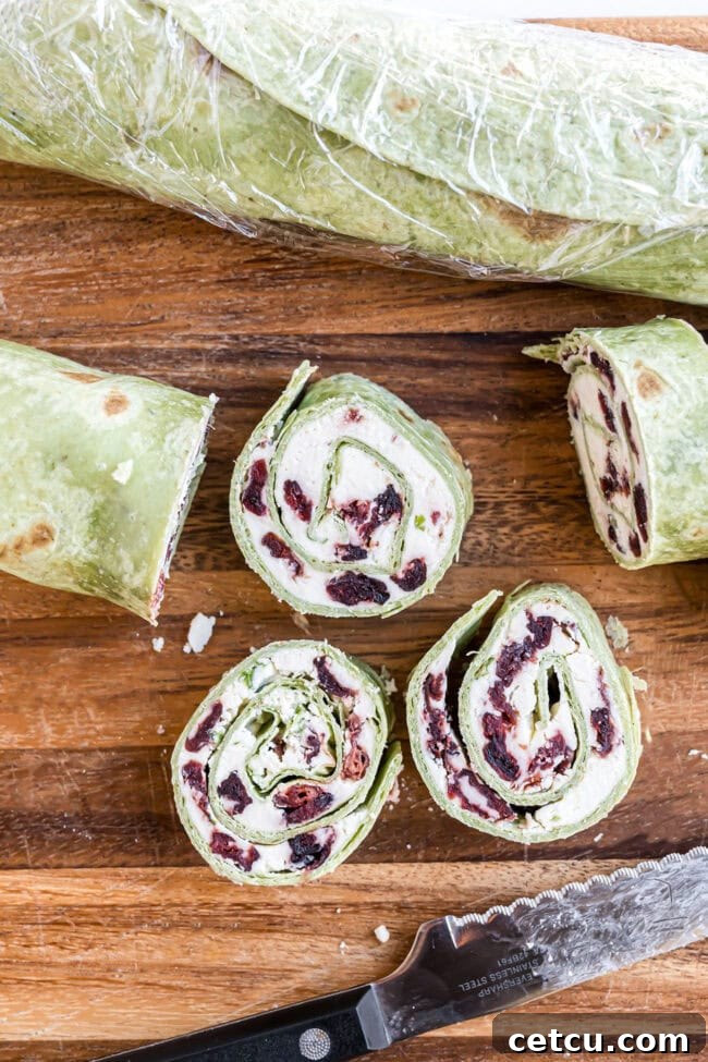 Cranberry Swirl Christmas Tree Bites 5 slicing cranberry feta pinwheels