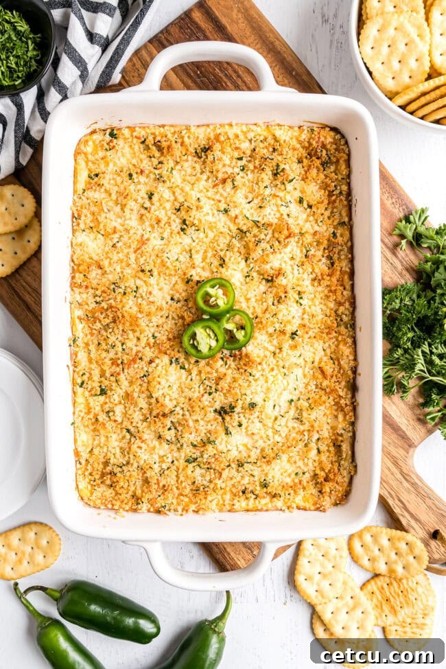Creamy, cheesy baked jalapeño popper dip with vibrant green jalapeños in a white baking dish, ready to be served.