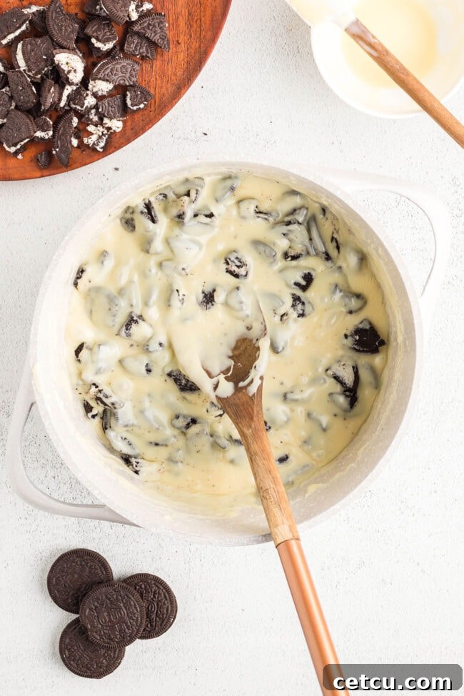 Oreo fudge step 3: Mixing crushed Oreos into the melted fudge mixture