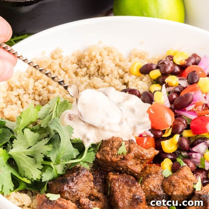 Close-up of a Southwest steak bowl with tender sirloin steak, rice, black bean and corn salad, and creamy Southwest sauce.