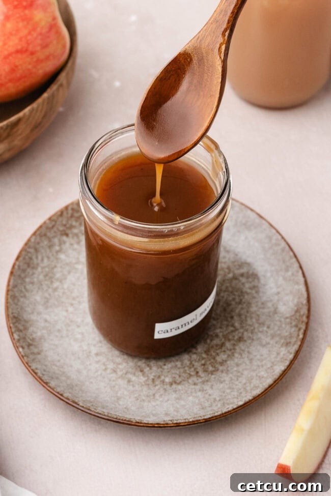 Salted apple cider caramel sauce drizzling into a glass jar.