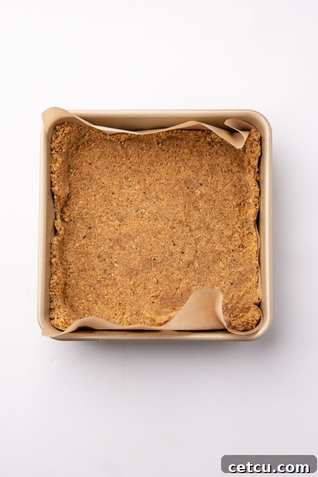 Scoopable Salted Caramel Cheesecake Recipe 4 Graham cracker crust pressed into a parchment-lined square baking dish