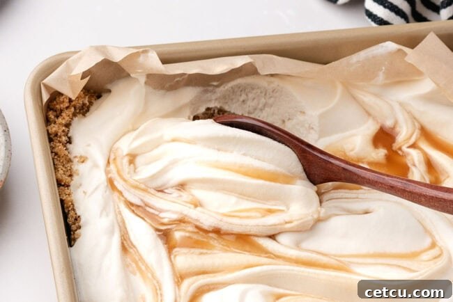 Scoopable Salted Caramel Cheesecake Recipe 7 Spoon scooping creamy salted caramel cheesecake from a graham cracker crust