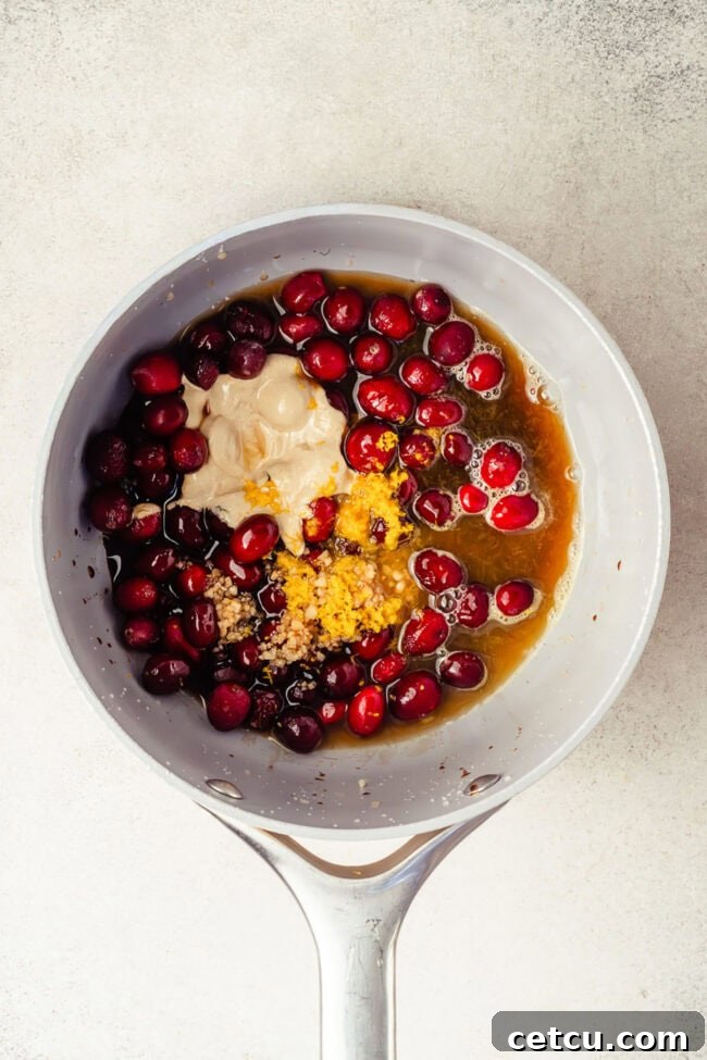 Cranberry Orange Glazed Salmon Recipe with Citrus Sauce 6 Cranberries, orange zest, garlic, and other glaze ingredients in a saucepan.